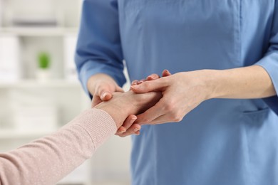 Arthritis symptoms. Doctor examining patient's wrist in hospital, closeup