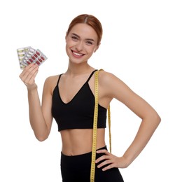 Photo of Happy young woman with pills and measuring tape on white background. Weight loss