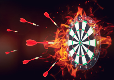 Image of Burning board and darts on dark background