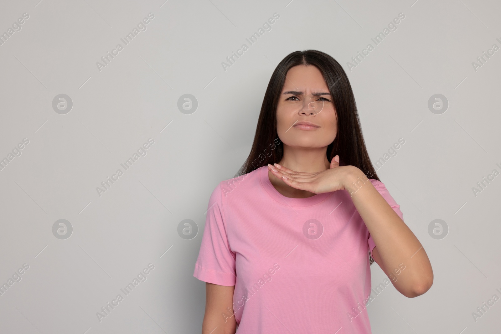 Photo of Aggressive young woman on light grey background, space for text