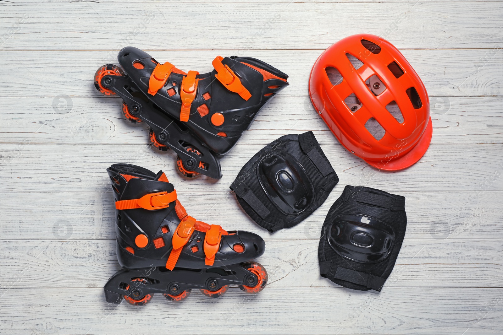 Photo of Flat lay composition with inline roller skates on wooden background