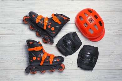 Photo of Flat lay composition with inline roller skates on wooden background