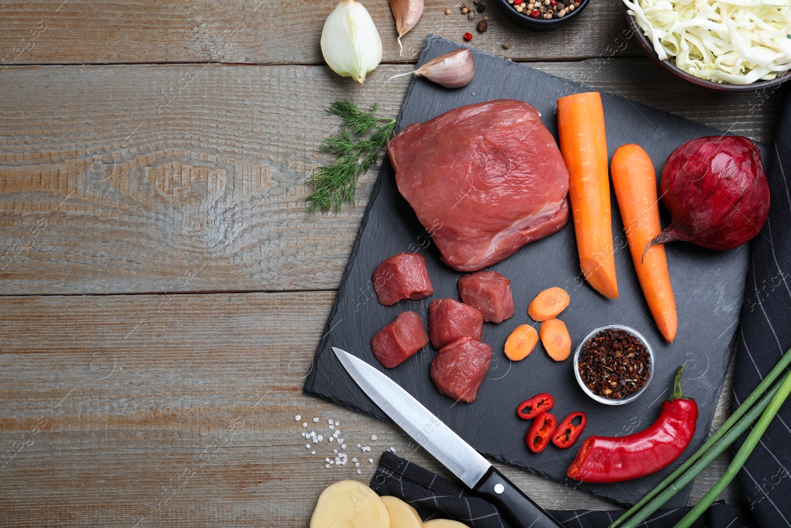 Photo of Fresh borscht ingredients on wooden table, flat lay. Space for text