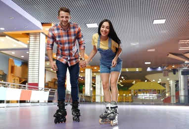 Young couple spending time at roller skating rink