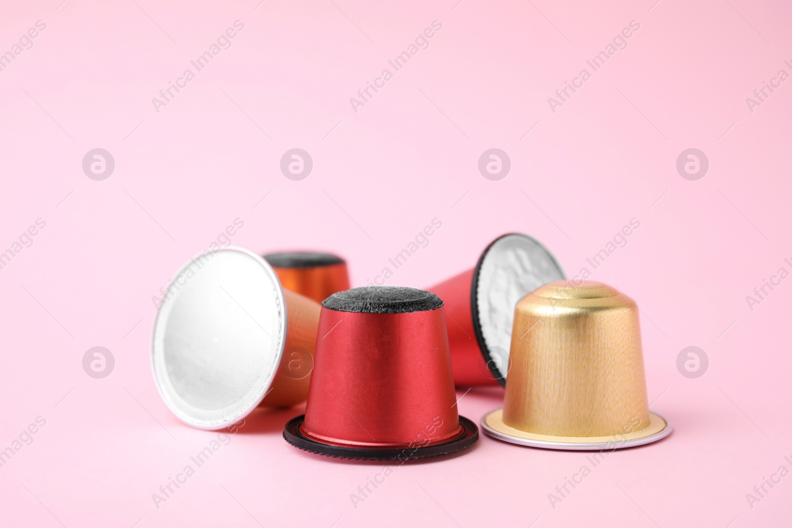 Photo of Many plastic coffee capsules on pink background, closeup