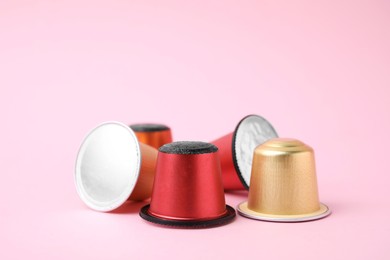 Photo of Many plastic coffee capsules on pink background, closeup