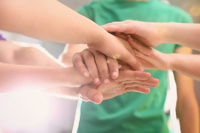 Photo of Group of volunteers joining hands together, closeup