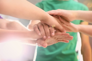 Group of volunteers joining hands together, closeup