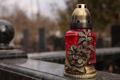 Photo of Grave lantern on granite surface at cemetery, space for text