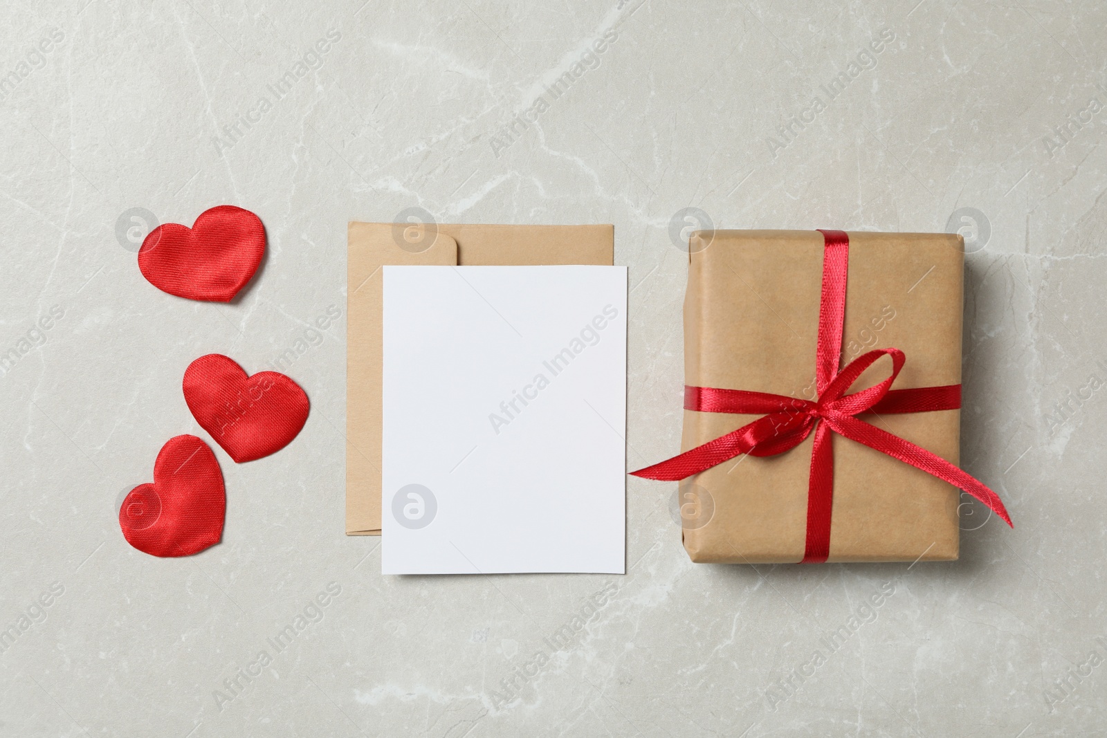 Photo of Flat lay composition with blank card on light background, space for text. Valentine's Day celebration