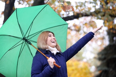 Woman with umbrella in autumn park on rainy day