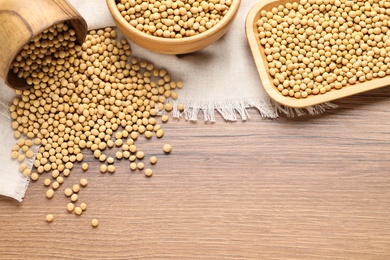 Photo of Organic soy beans on wooden table, flat lay. Space for text