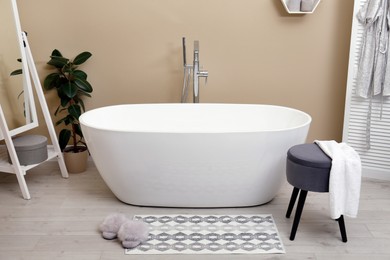 Photo of Cozy bathroom interior with stylish ceramic tub