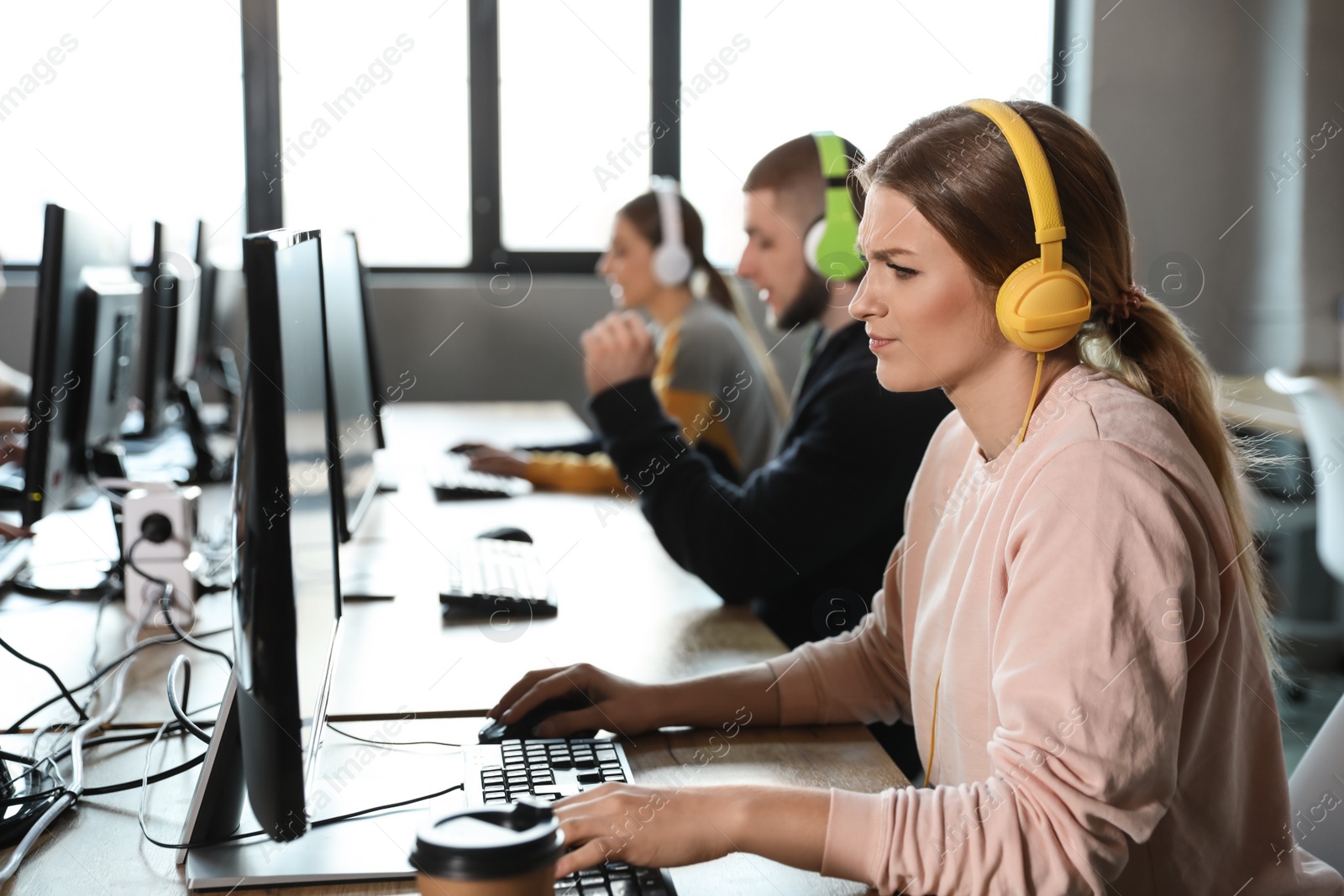 Photo of Emotional woman playing video game in internet cafe