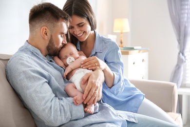 Happy couple with their newborn baby at home