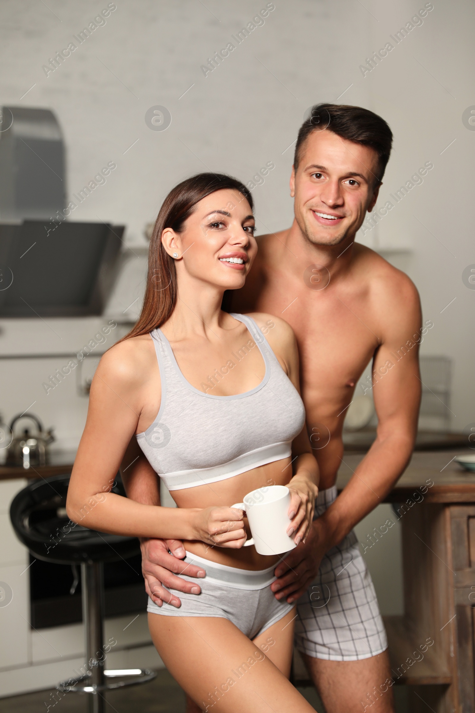 Photo of Happy couple wearing underwear in modern kitchen