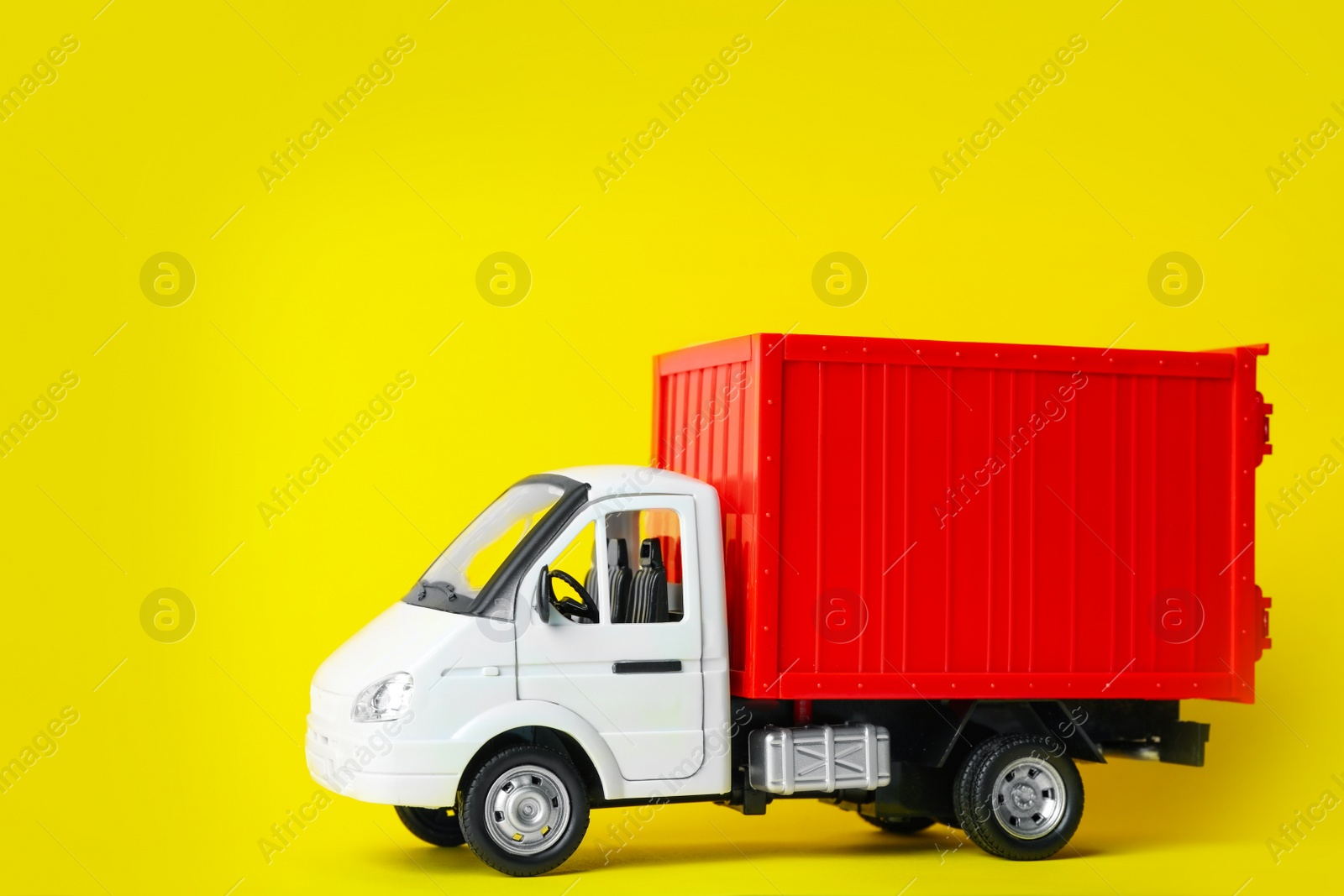 Photo of Toy truck on yellow background, space for text. Logistics and wholesale concept