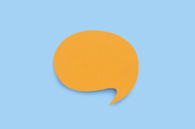 Paper speech bubble on light blue background, top view. Space for text