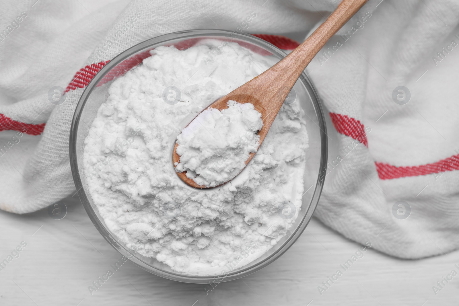 Photo of Bowl and spoon of starch on white wooden table, top view