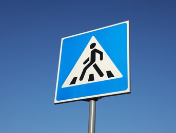 Photo of traffic sign Pedestrian Crossing against blue sky, low angle view