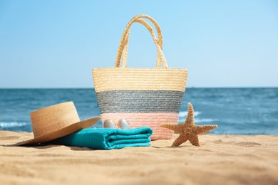 Stylish beach accessories on sand near sea