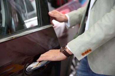 Man opening door of new car, closeup