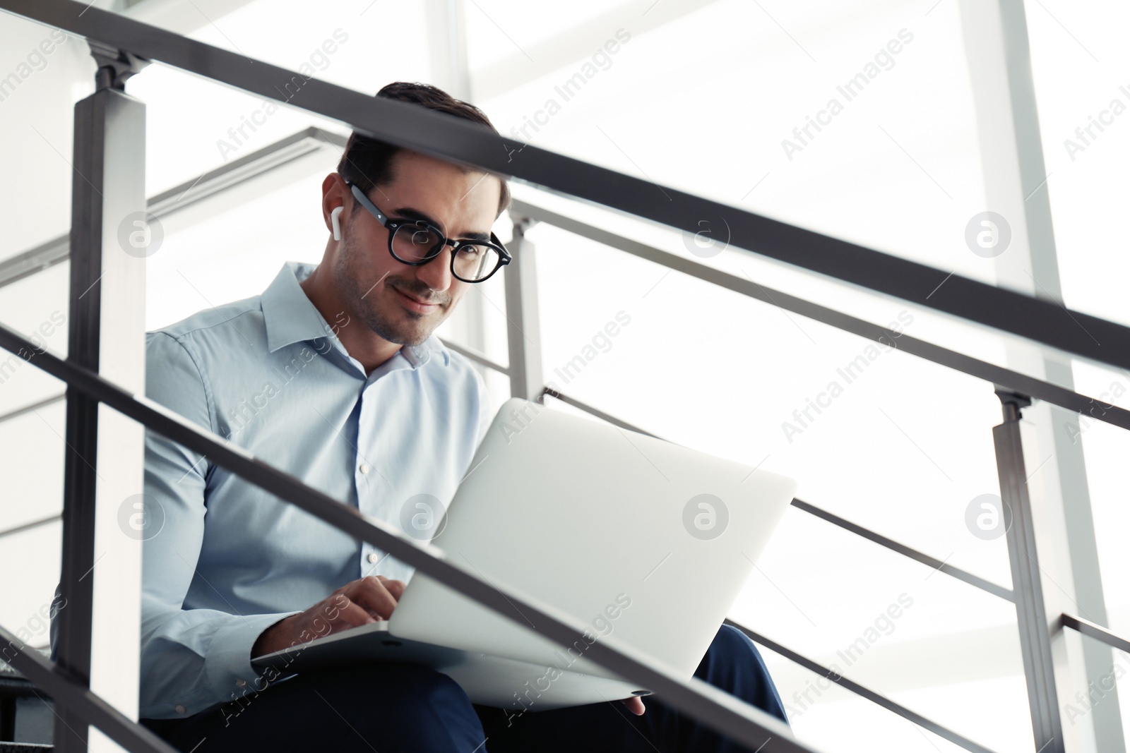 Photo of Portrait of young man with laptop indoors