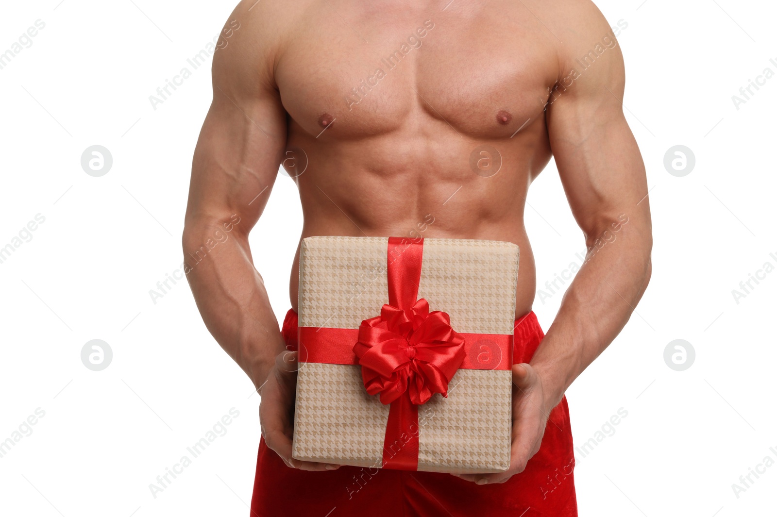 Photo of Attractive young man with muscular body in Santa hat holding Christmas gift box on white background, closeup