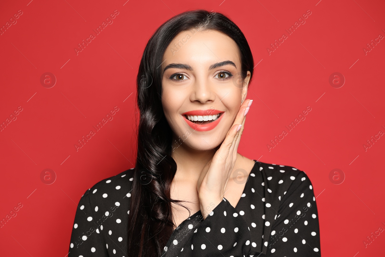 Photo of Portrait of surprised woman on red background