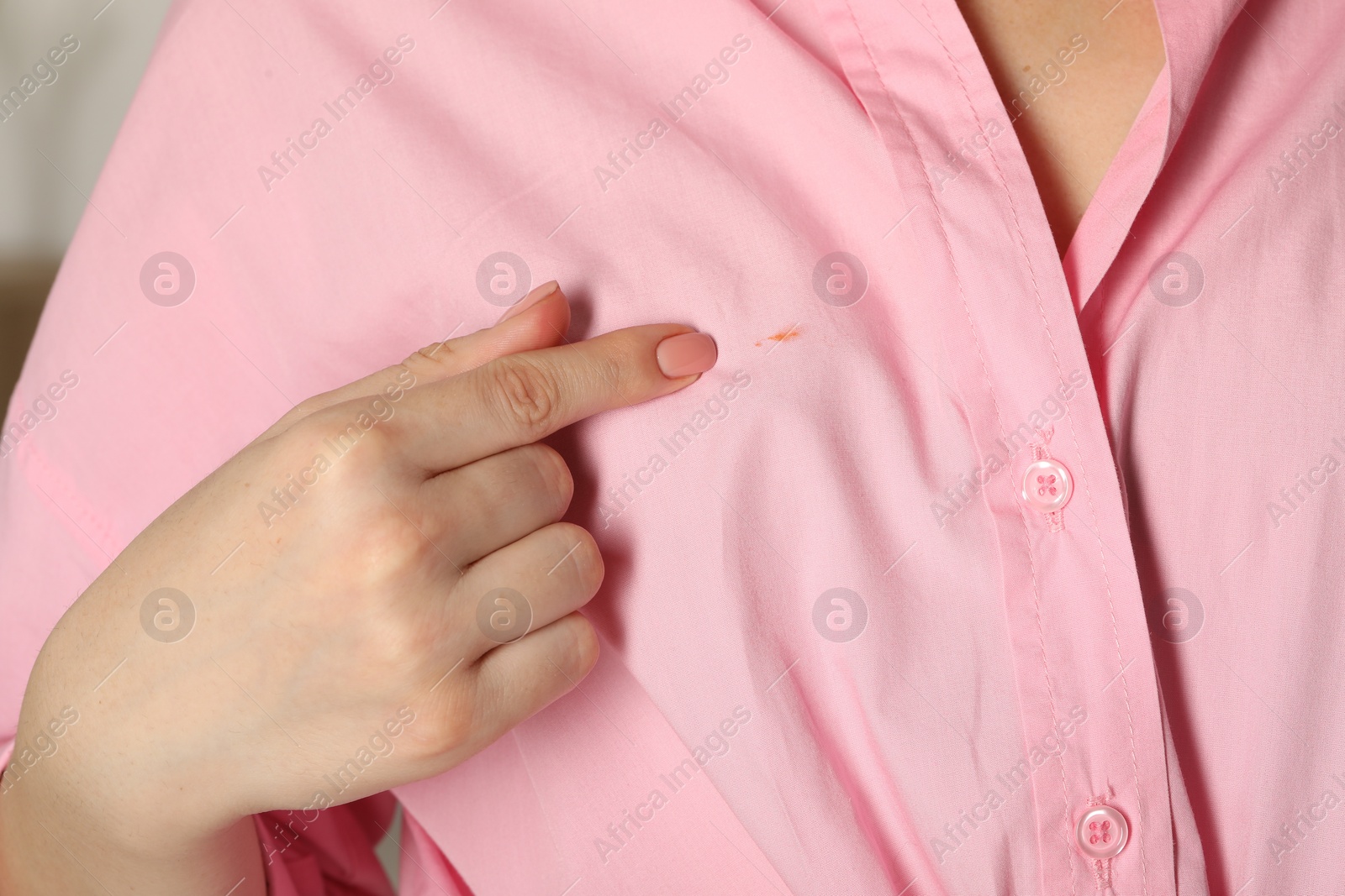 Photo of Woman showing stain on her shirt, closeup