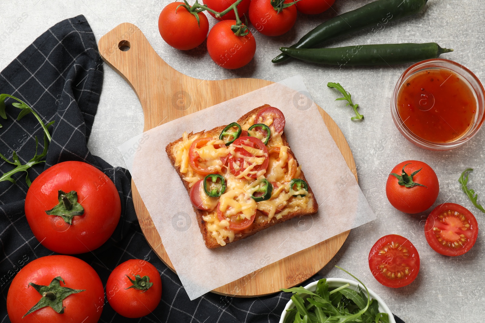 Photo of Tasty pizza toasts and ingredients on grey table, flat lay
