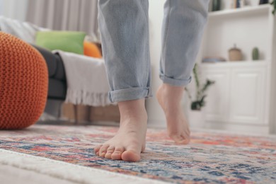 Woman standing on carpet with pattern in room, closeup