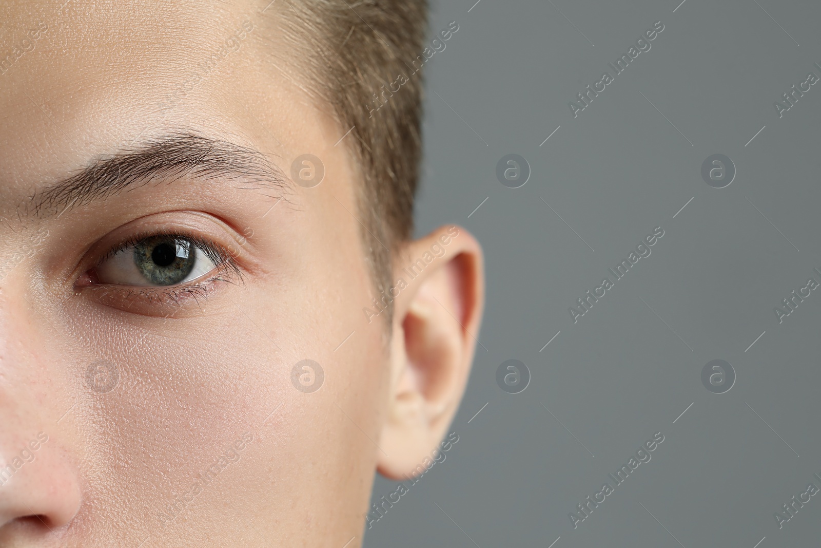 Photo of Perfect vision. Man with beautiful eyes on grey background, closeup. Space for text