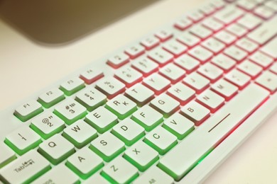 Modern RGB keyboard on white table indoors, closeup