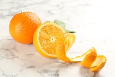 Photo of Orange fruits with peel on white marble table