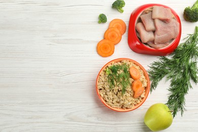 Photo of Pet food and natural ingredients on white wooden table, flat lay. Space for text