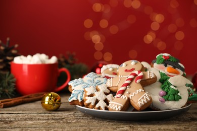 Photo of Sweet Christmas cookies and decor on wooden table against blurred festive lights
