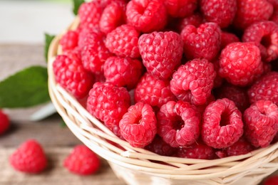 Photo of Tasty ripe raspberries in wicker basket, closeup