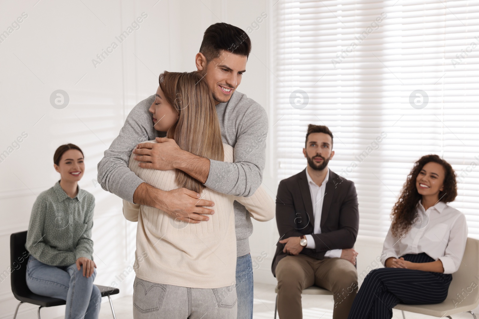 Photo of Psychotherapist working with patient at group session indoors