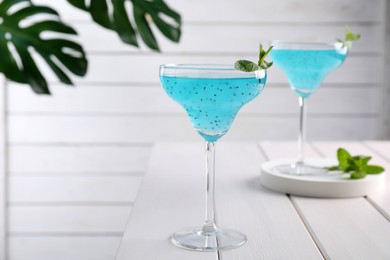 Photo of Delicious cocktail in glasses on white wooden table