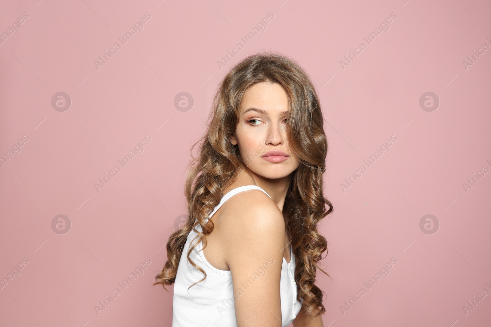Photo of Portrait of beautiful young woman with shiny wavy hair on color background