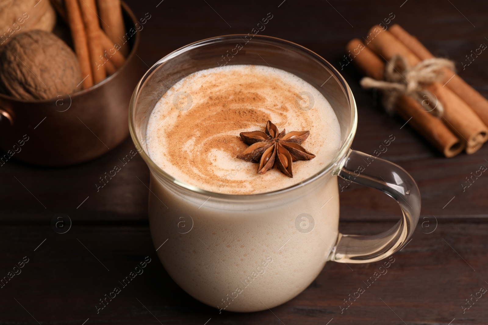 Photo of Delicious eggnog with spices on wooden table