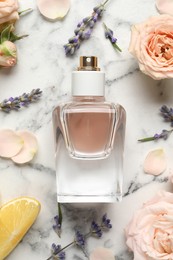 Flat lay composition with bottle of perfume and fresh citrus fruit on white marble table