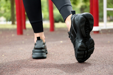 Photo of Woman in comfortable stylish sneakers outdoors, closeup