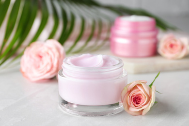 Photo of Jar of organic cream and flower on light table