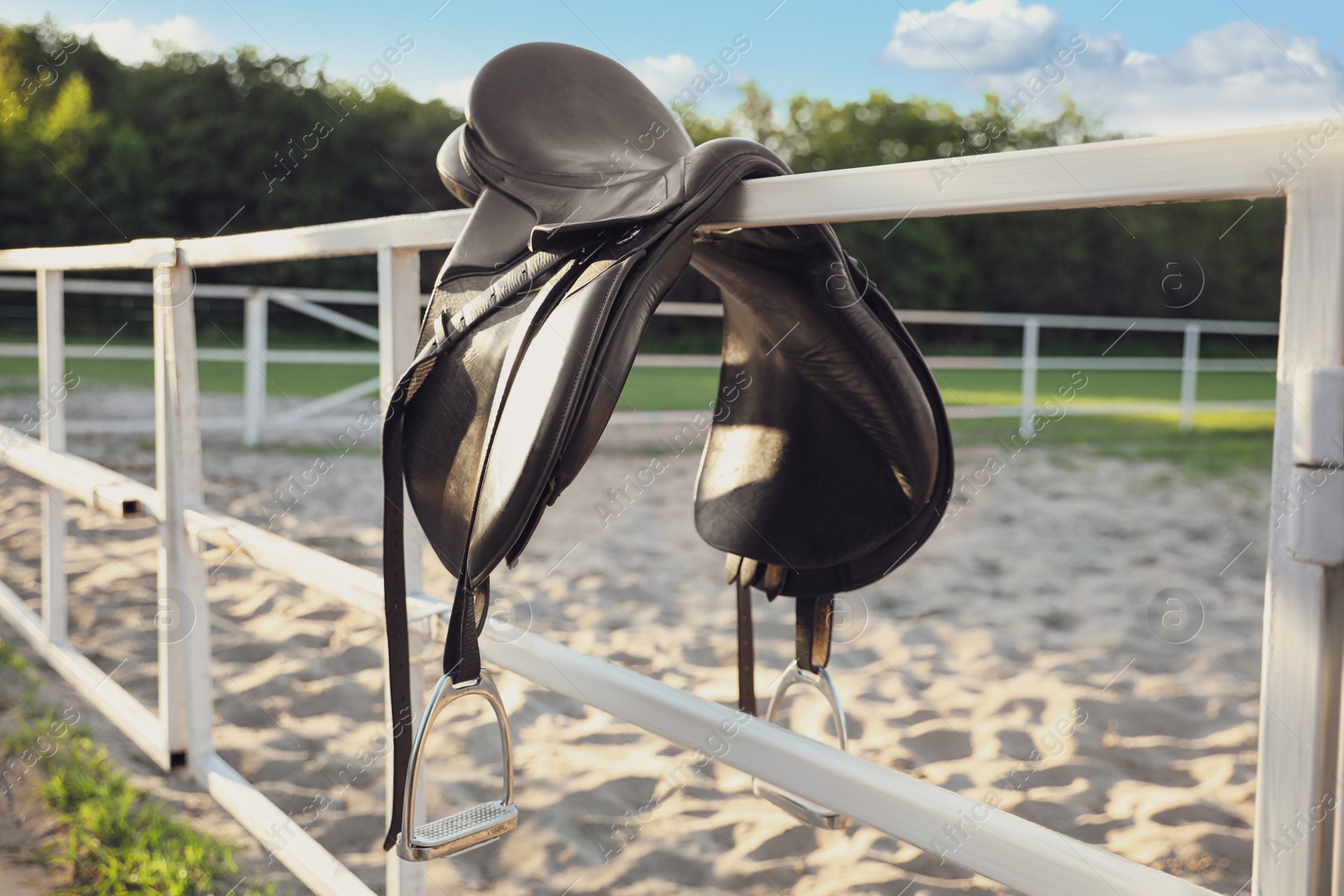 Photo of Leather horse saddle on wooden fence outdoors