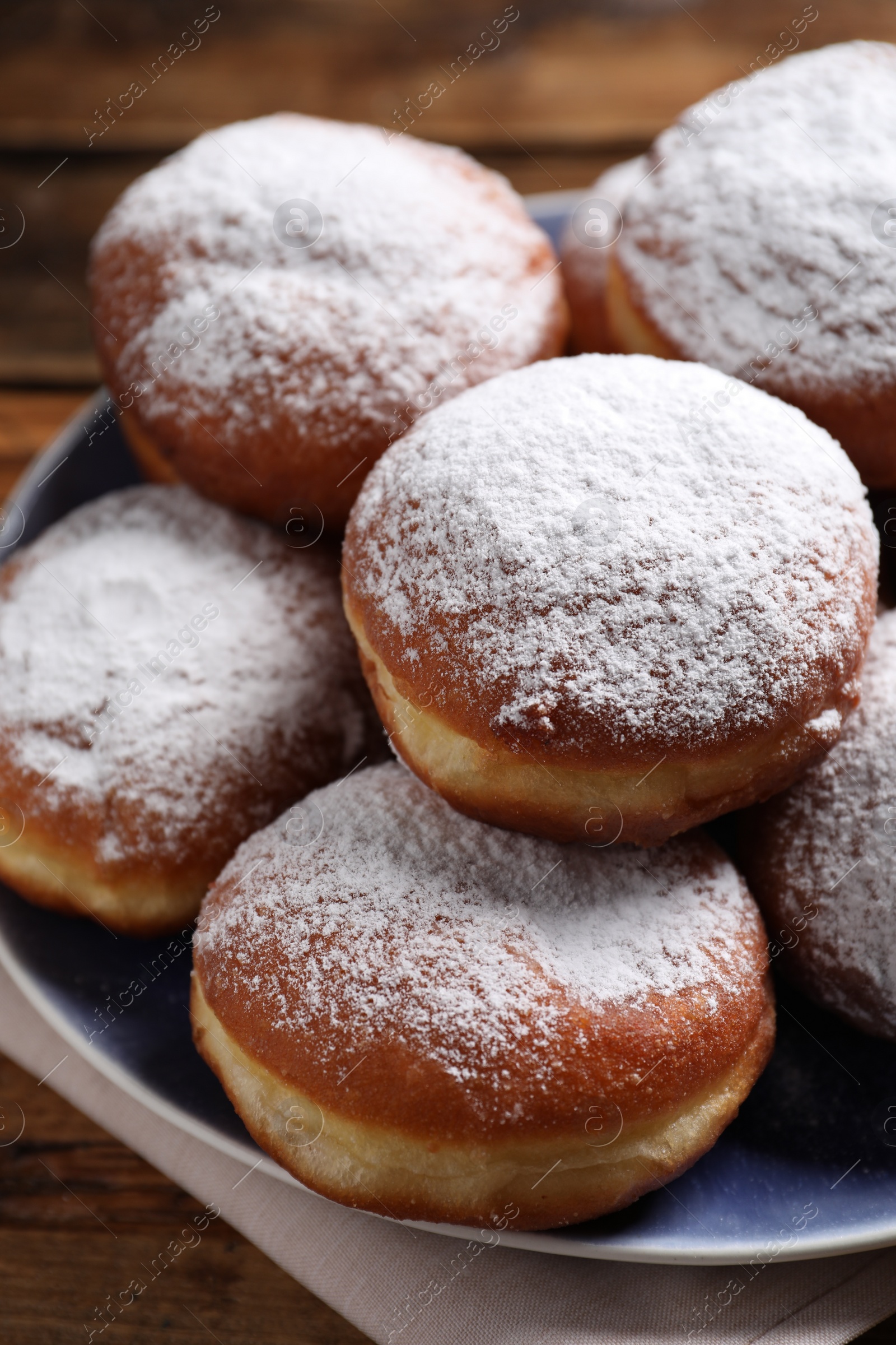 Photo of Delicious sweet buns with powdered sugar on table, closeup