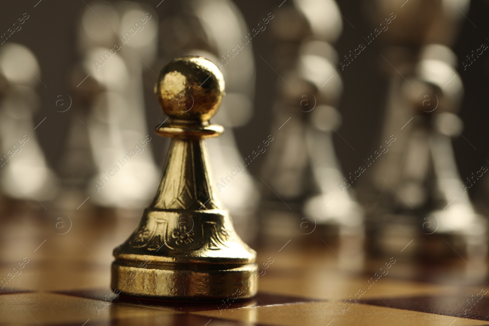 Photo of Chessboard with game pieces on grey background, closeup
