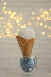 Cotton candy in waffle cone against blurred lights