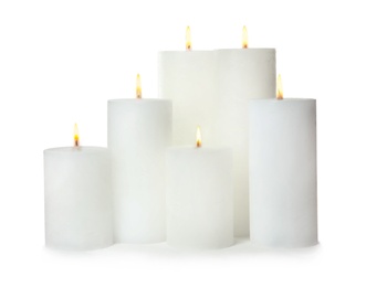 Photo of Many alight wax candles on white background